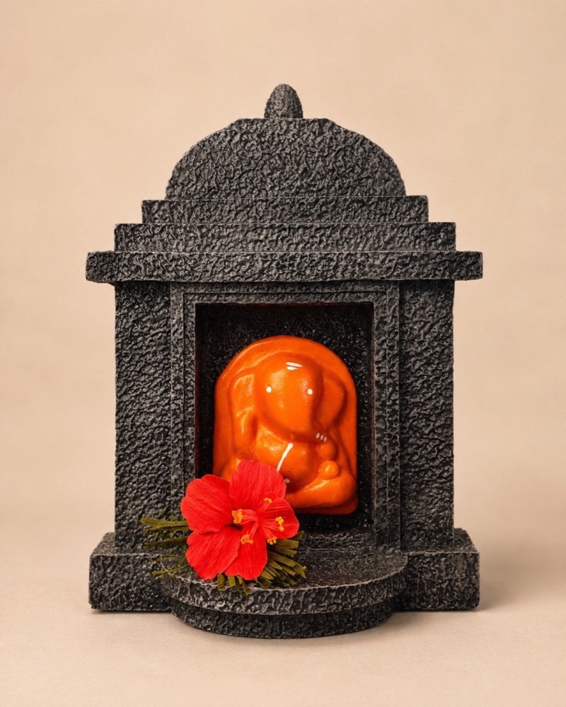 The terracotta Ganesha seated in his stone temple, seen from the front.