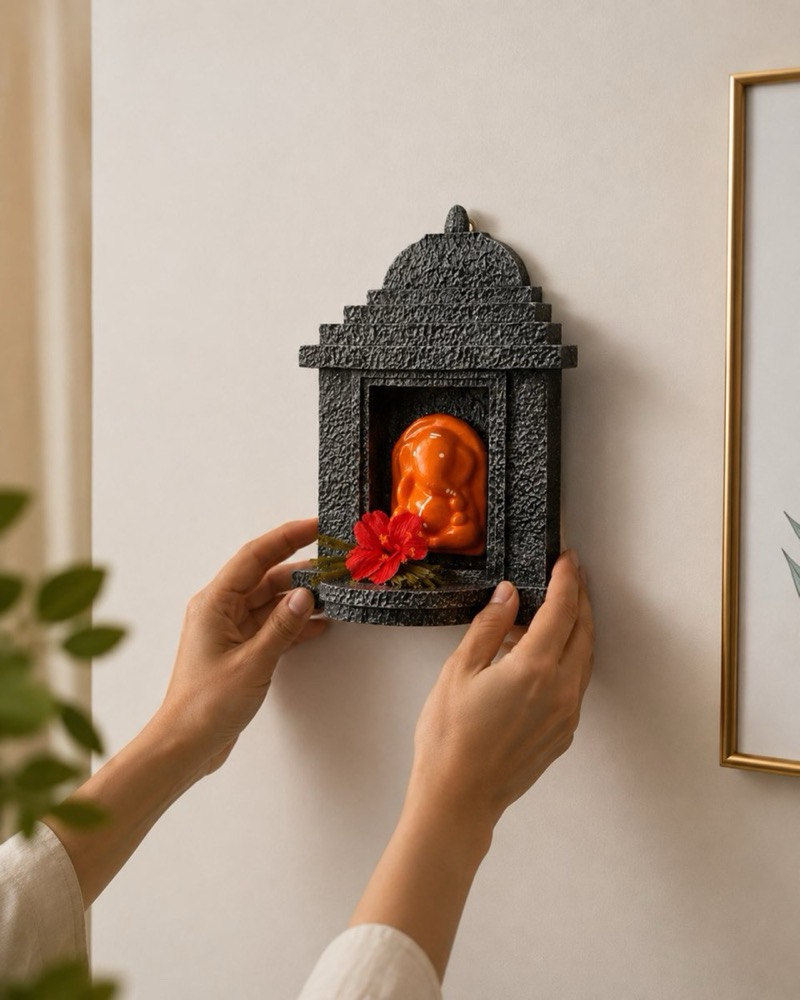 Two hands placing the temple onto a wall.